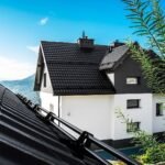 Plieninė modulinė stogo čerpė German ant naujo namo stogo. Juodas stogas, baltos sienos.