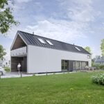 Modernus namas su pilnai paslėpta lietaus nuvedimo sistema, balta fasado spalva ir tamsiu stogu.