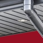 Pilkas plastikinis stogo pakalimas su įmontuotu apšvietimu ir lietvamzdžiu.